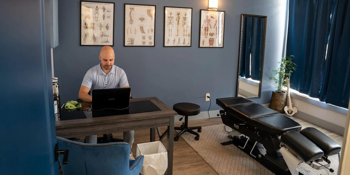 A chiropractic clinic suite, with the practice team working across the front desk and treatment rooms.